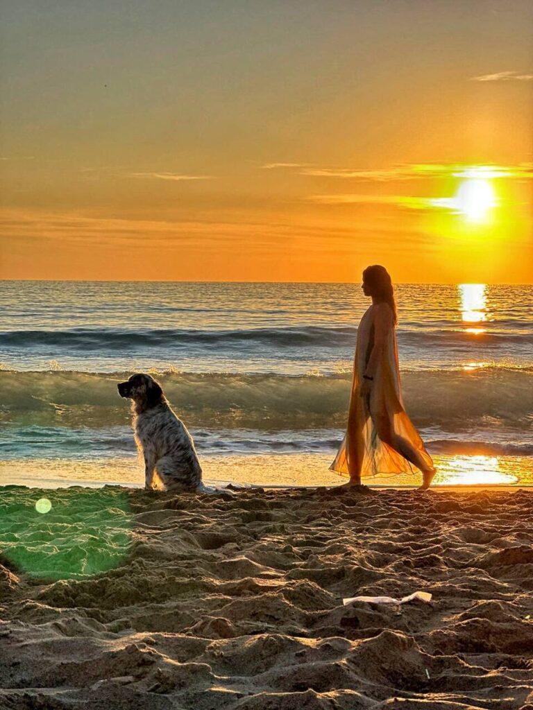 Zachód słońca na Korfu – kobieta i pies na plaży, złote światło i fale